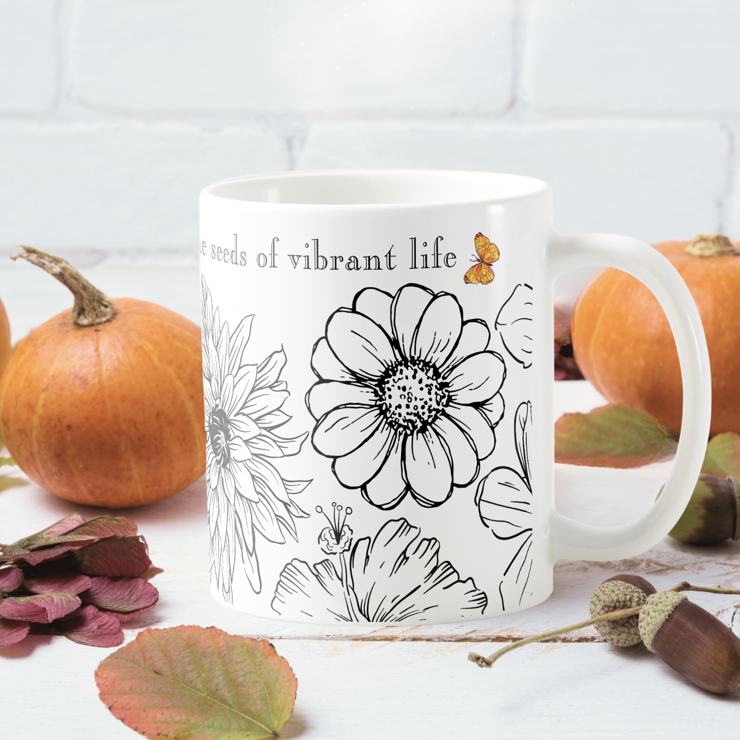 White mug with a black and white flower drawing and a small butterfly.