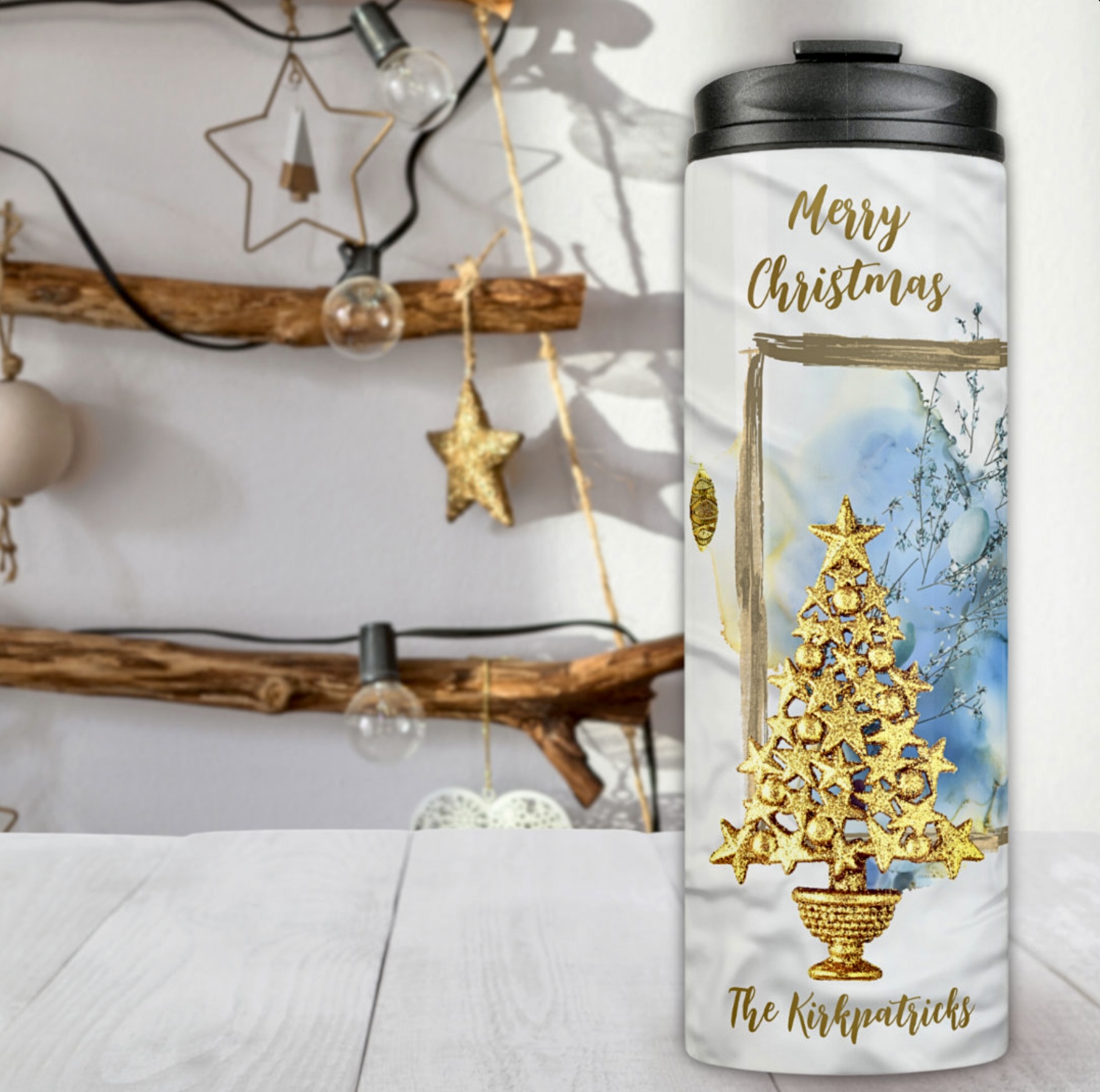 Thermal tumbler with golden Christmas tree on a blue frame.