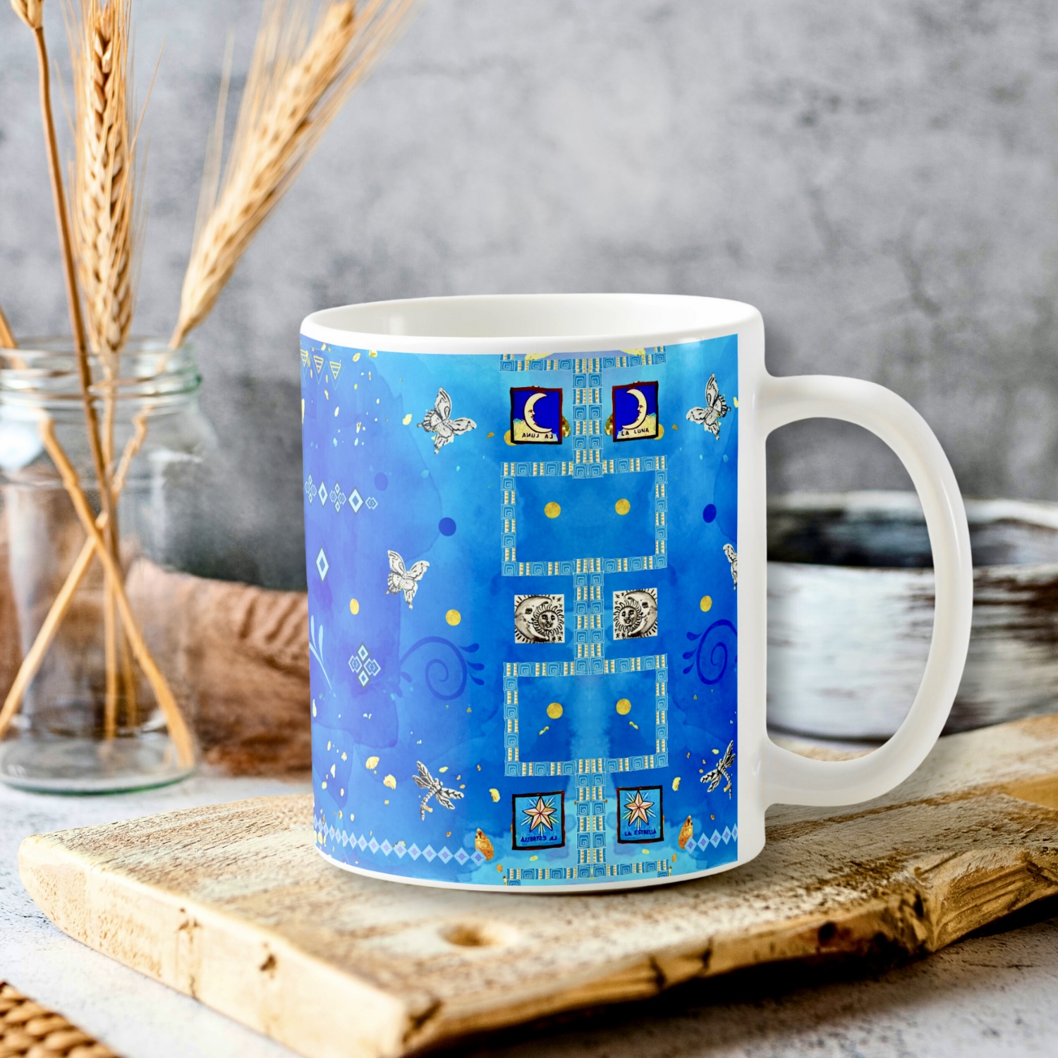 Blue mug with Mexican art motifs like the moon, the sun and little silver images. 