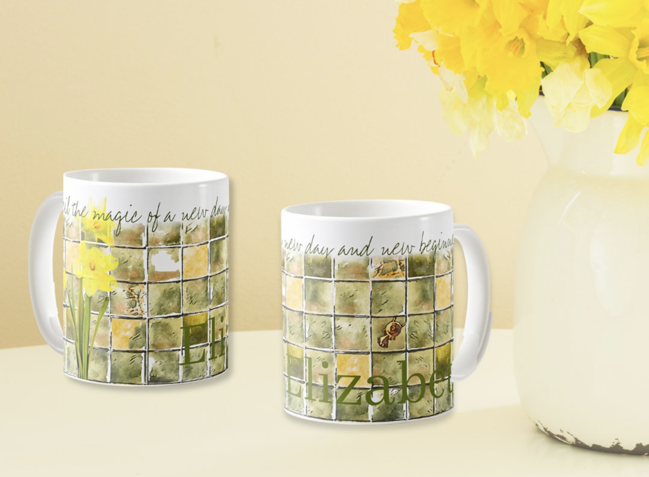 Two coffee mugs with watercolor daffodils illustration in soft yellow and green colors. Includes inspirational message that says Unveil the magic of a new day and new beginnings.