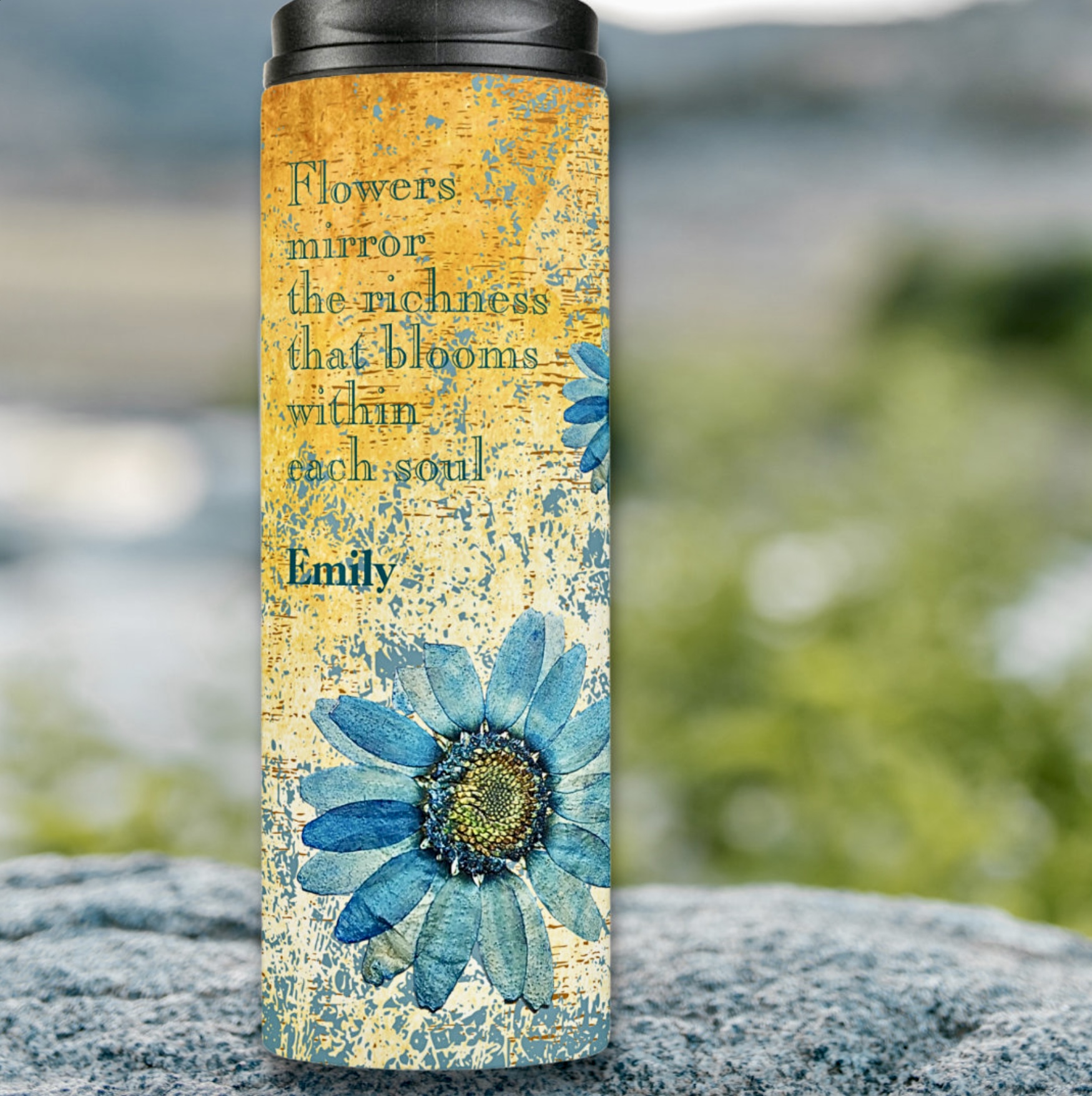 Thermal tumbler with gerbera flowers and inspirational quote in blue colors, with a orange ochre washout background.