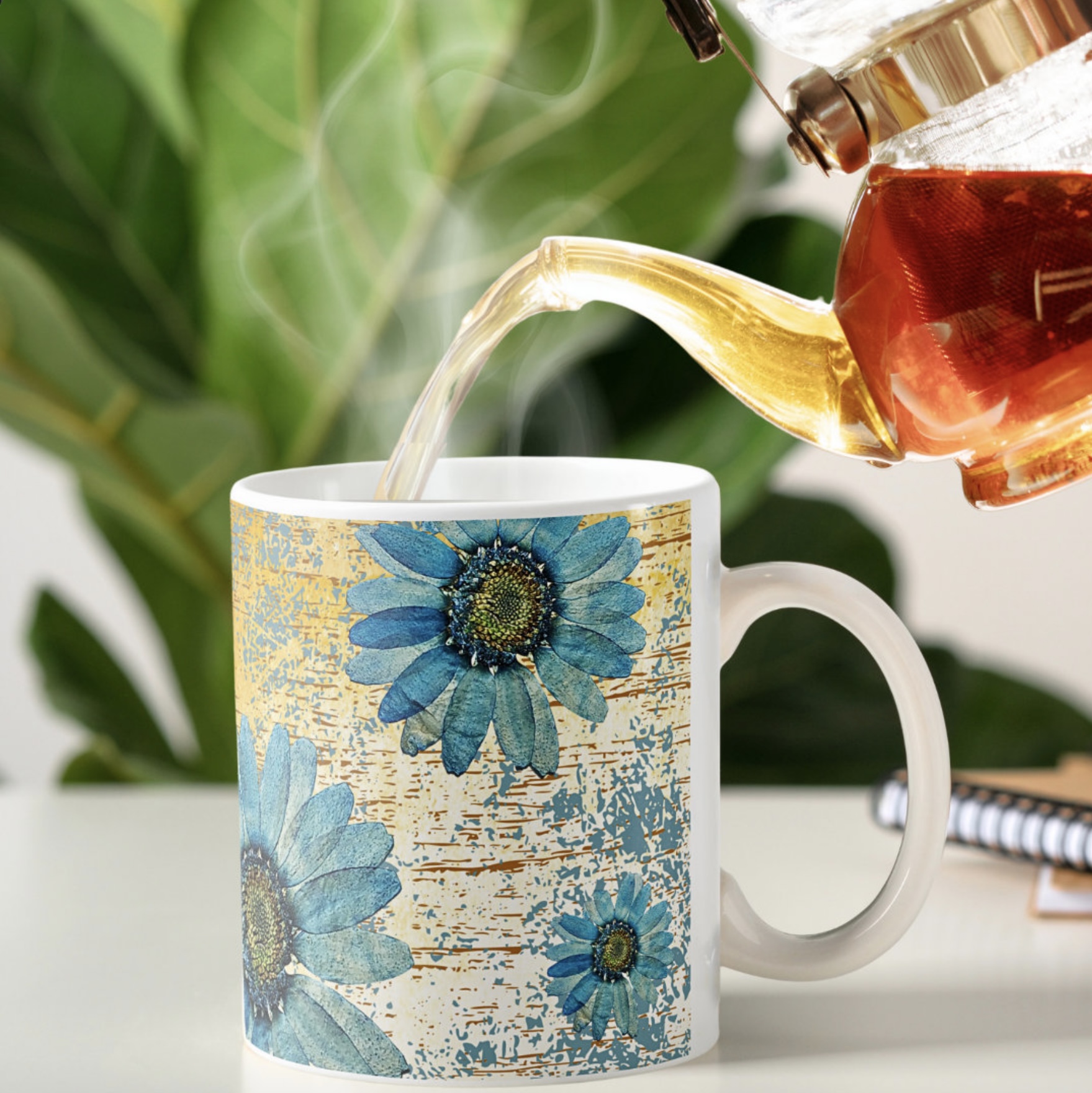 Serving hot coffee in a mug with blue gerberas images on a yellow ochre washed out background. 