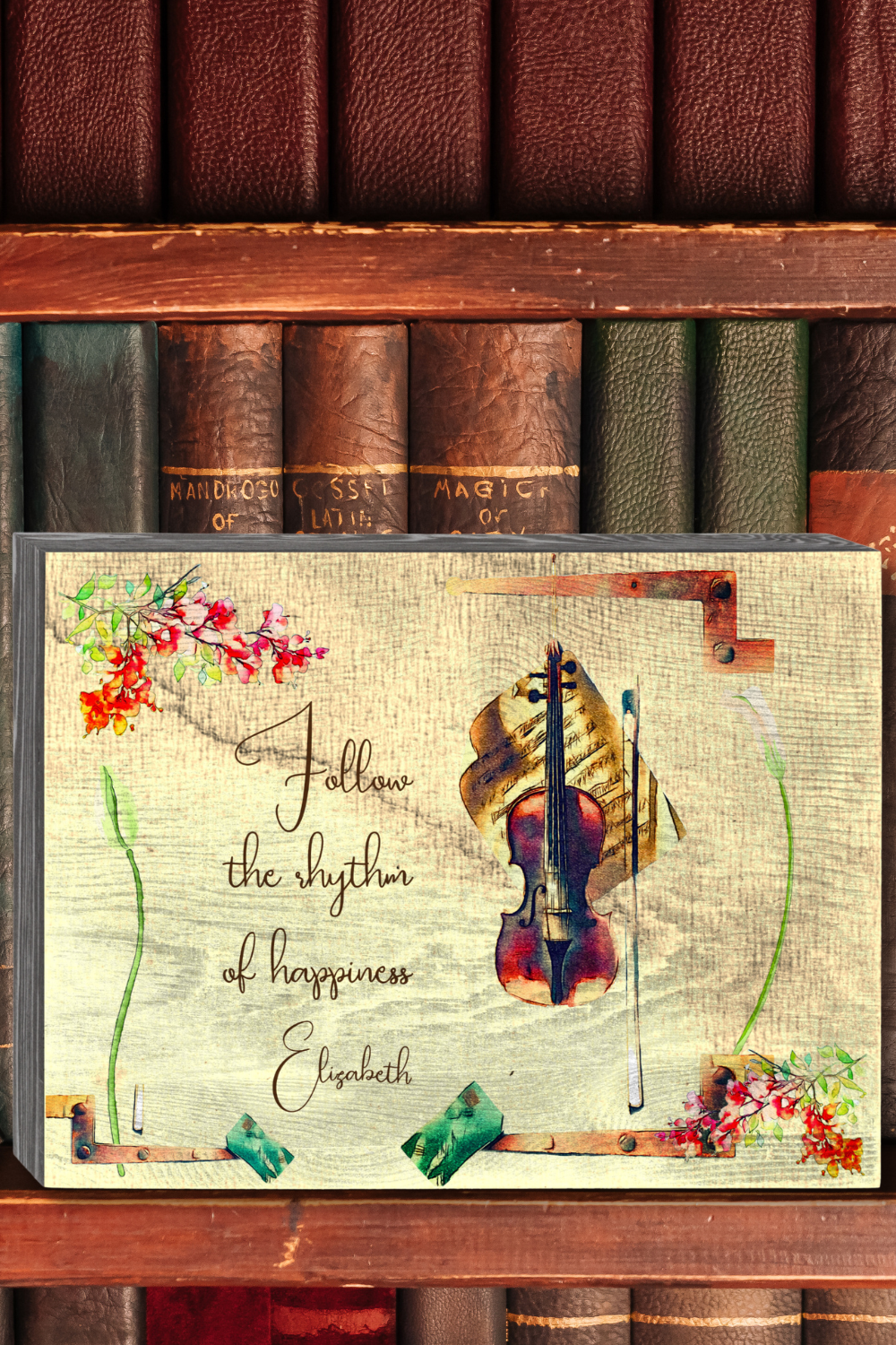 Decorative wooden box sign with vintage violin and bougainvilleas illustration on a washed out beige surface.