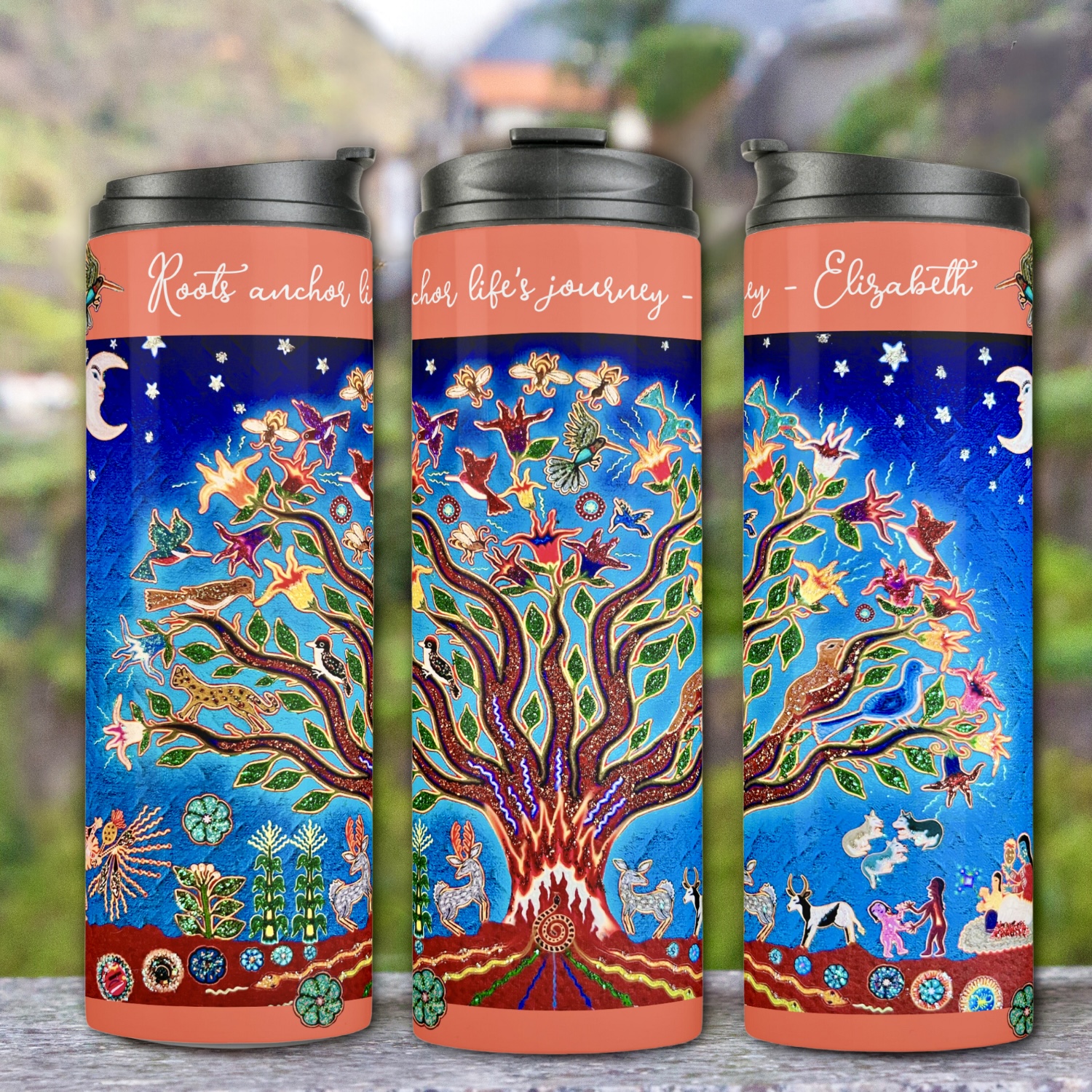 A thermal tumbler featuring the Night Sky Tree of Life design, shown from multiple sides. The intricate depiction of a majestic tree with swirling branches and sparkling stars is wrapped around the tumbler's surface. Against a neutral background, the vibrant colors and fine details of the design stand out, creating a striking visual appeal.