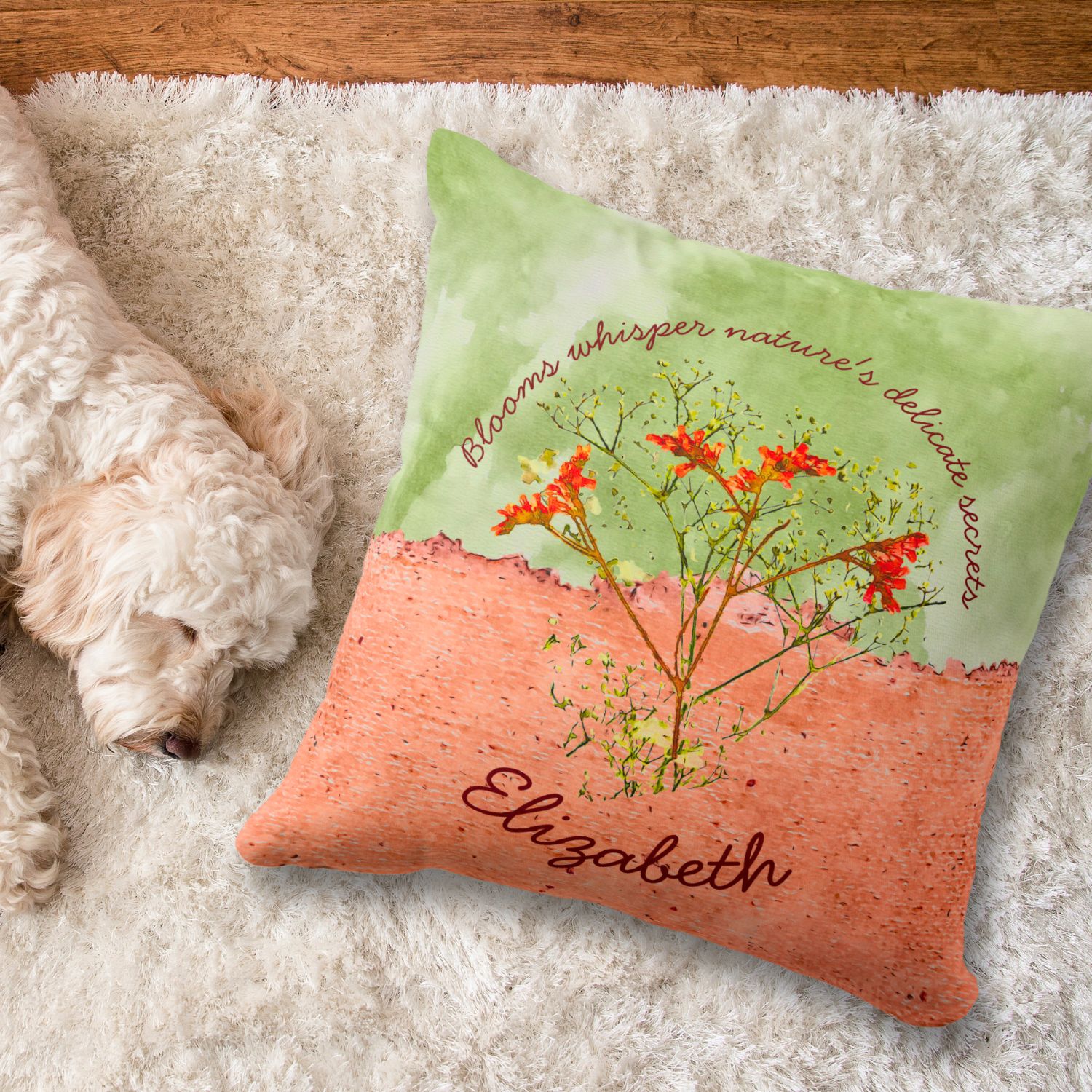 Peach and green throw pillow with orange and yellow flowers on a white rug, with a white dog sleeping on the side.