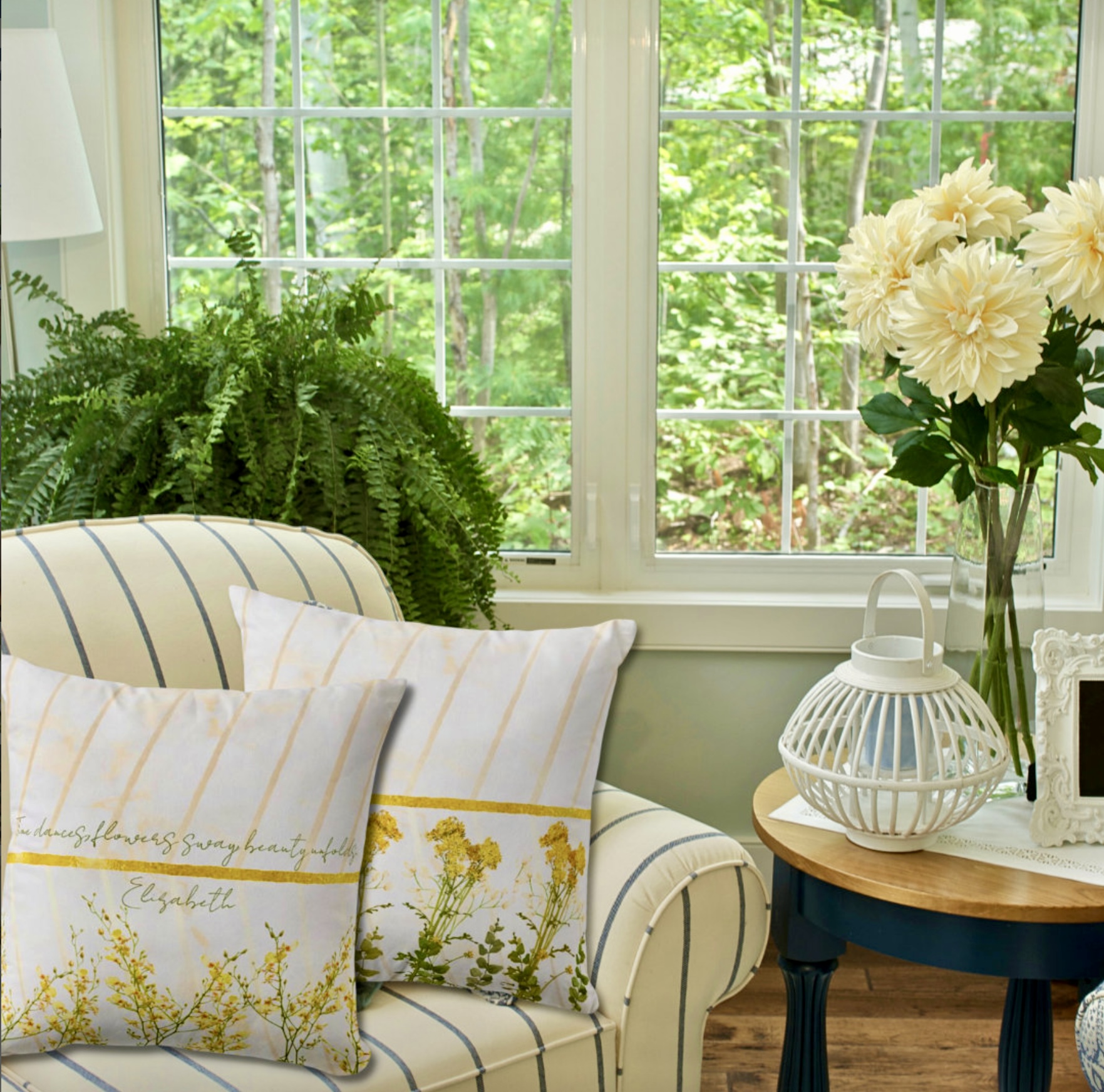 Romantic white throw pillows with yellow wildflowers and golden ribbons.