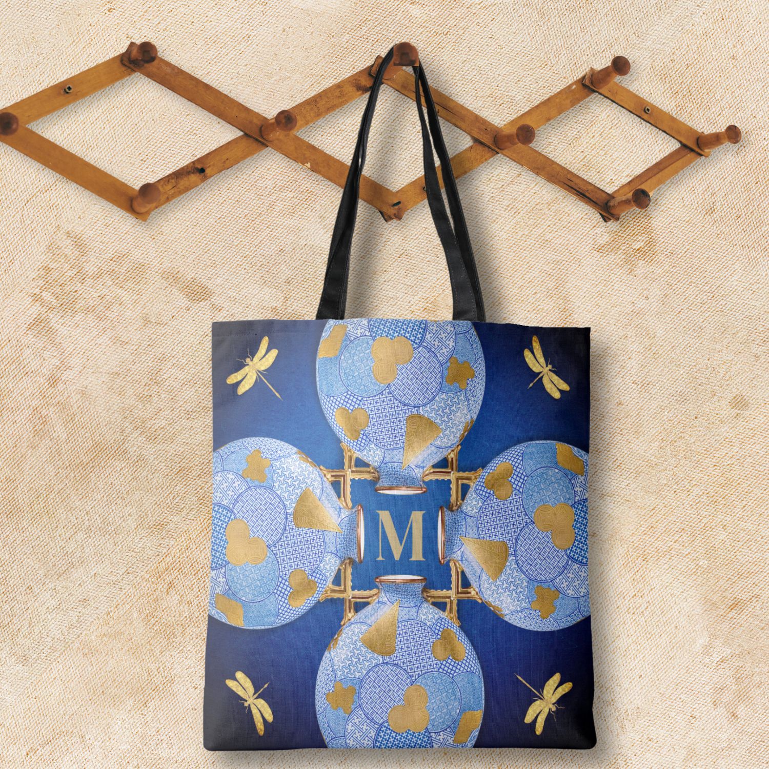 A unique luxury blue and gold tote bag, hanging against a rugged wall amidst an exquisite and simple setup.