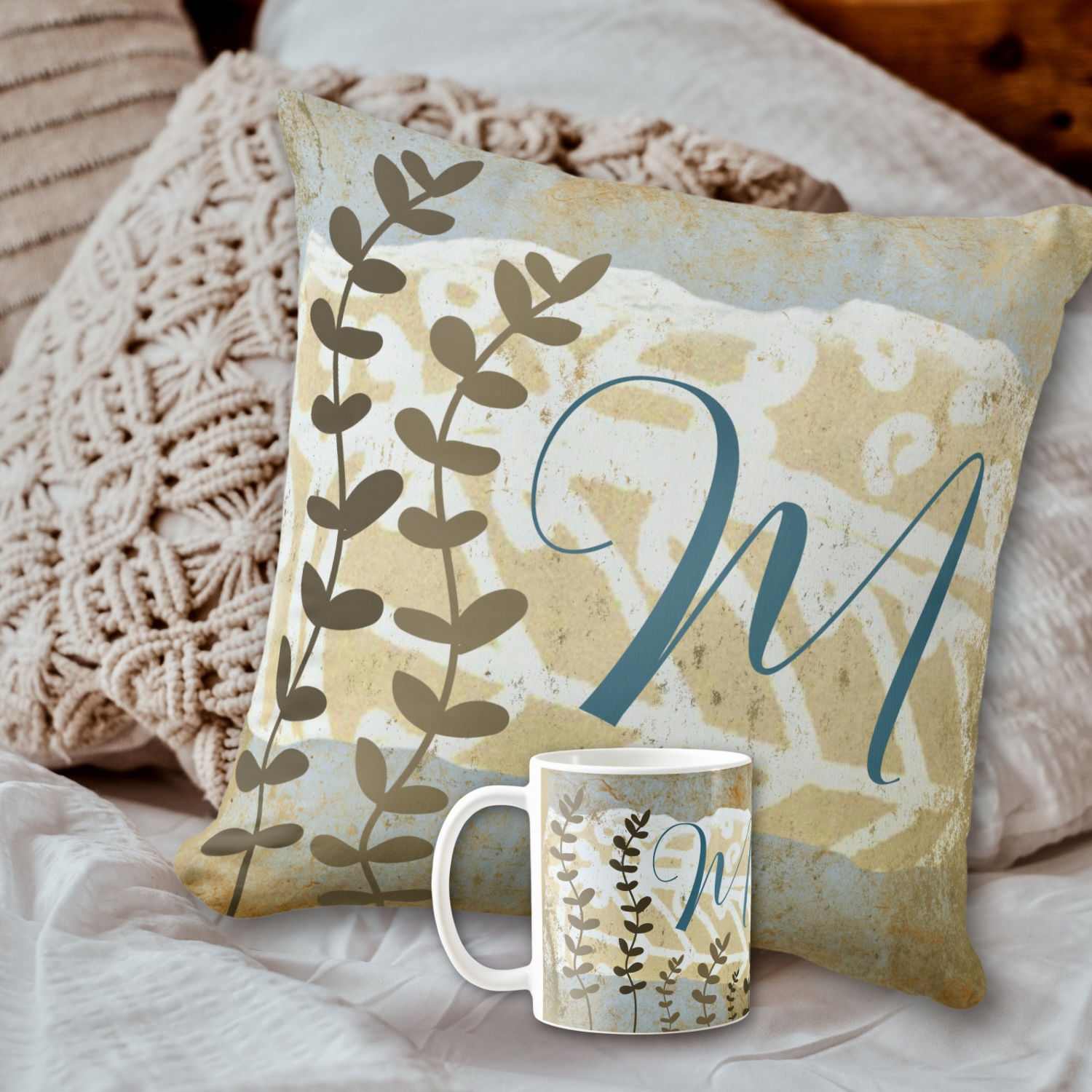 A monogrammed throw pillow in earthy tones of blue and beige, featuring personalized initials printed on the fabric.