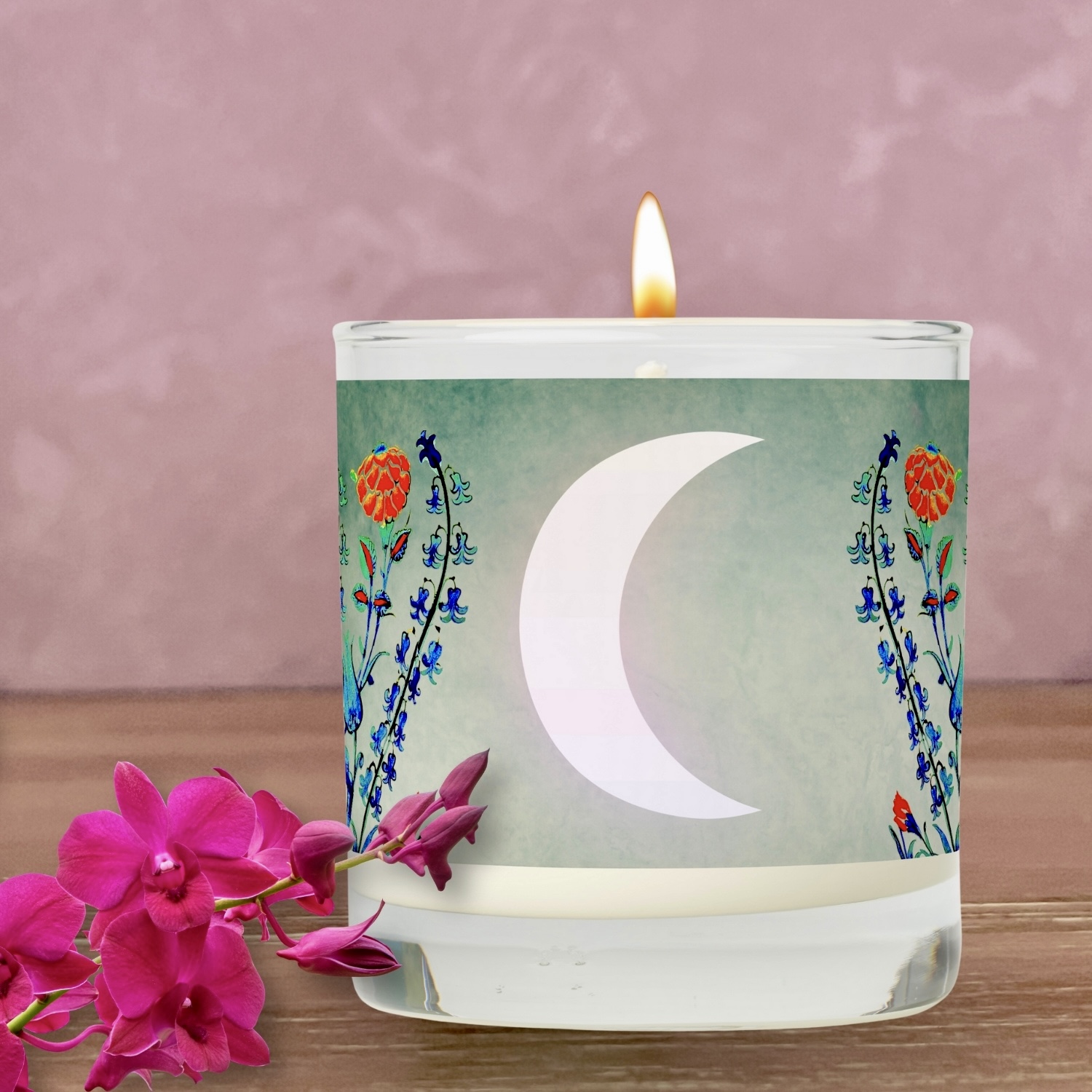 An Antique Floral Monogram Scented Candle featuring delicate floral patterns in shades of blue, green, and red, with a centered crescent moon, offering vintage charm and celestial elegance to any space.