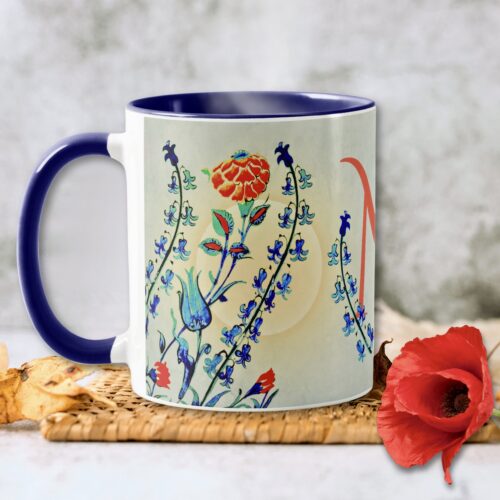 An Antique Floral Monogram Mug adorned with delicate floral patterns in shades of blue, green, and red, offering vintage charm and elegance to any beverage experience.