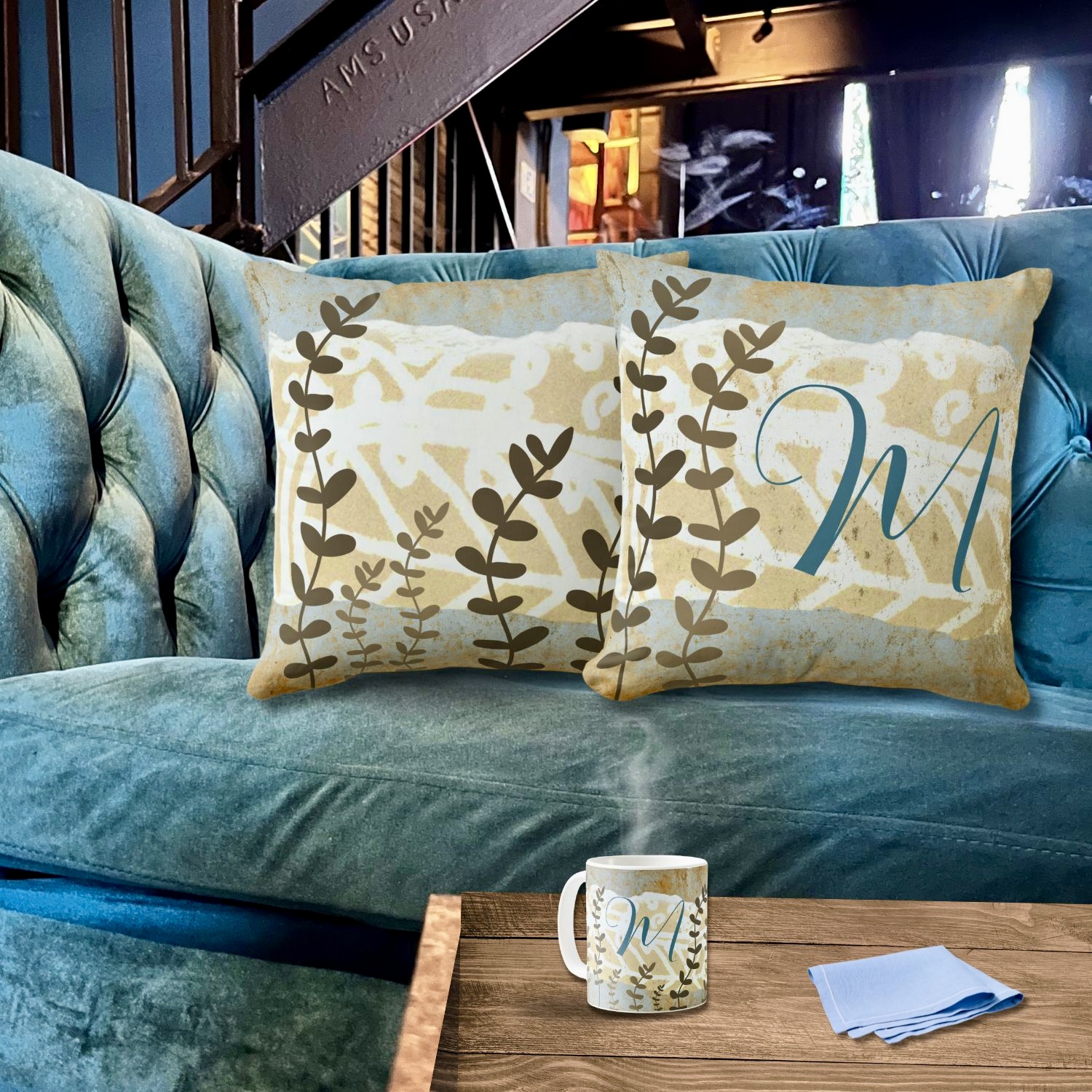 A beige neutral decorative pillow with a monogrammed blue initial accent.