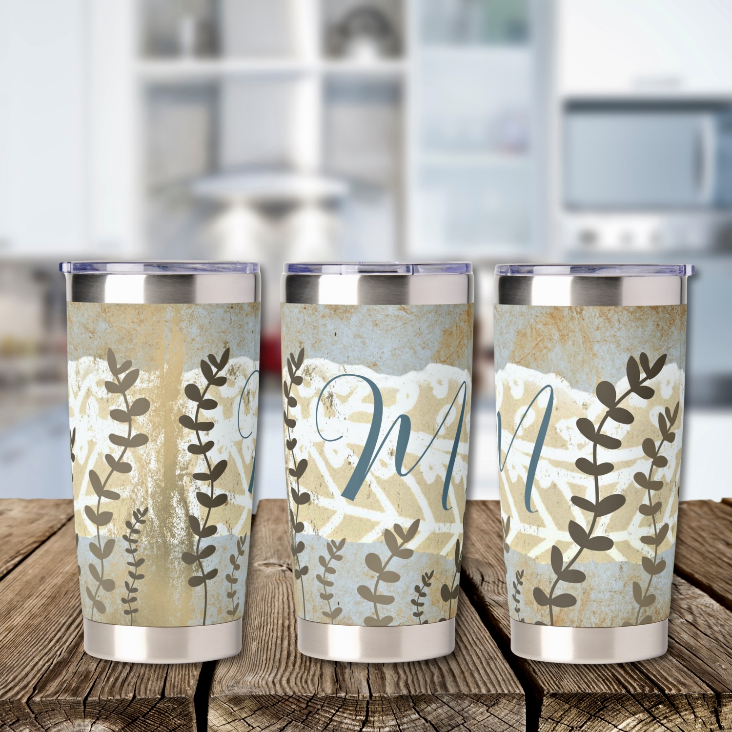 Three boho monogram thermal tumblers showing exact same design from three different perspectives. Earthy blue and brown colors.