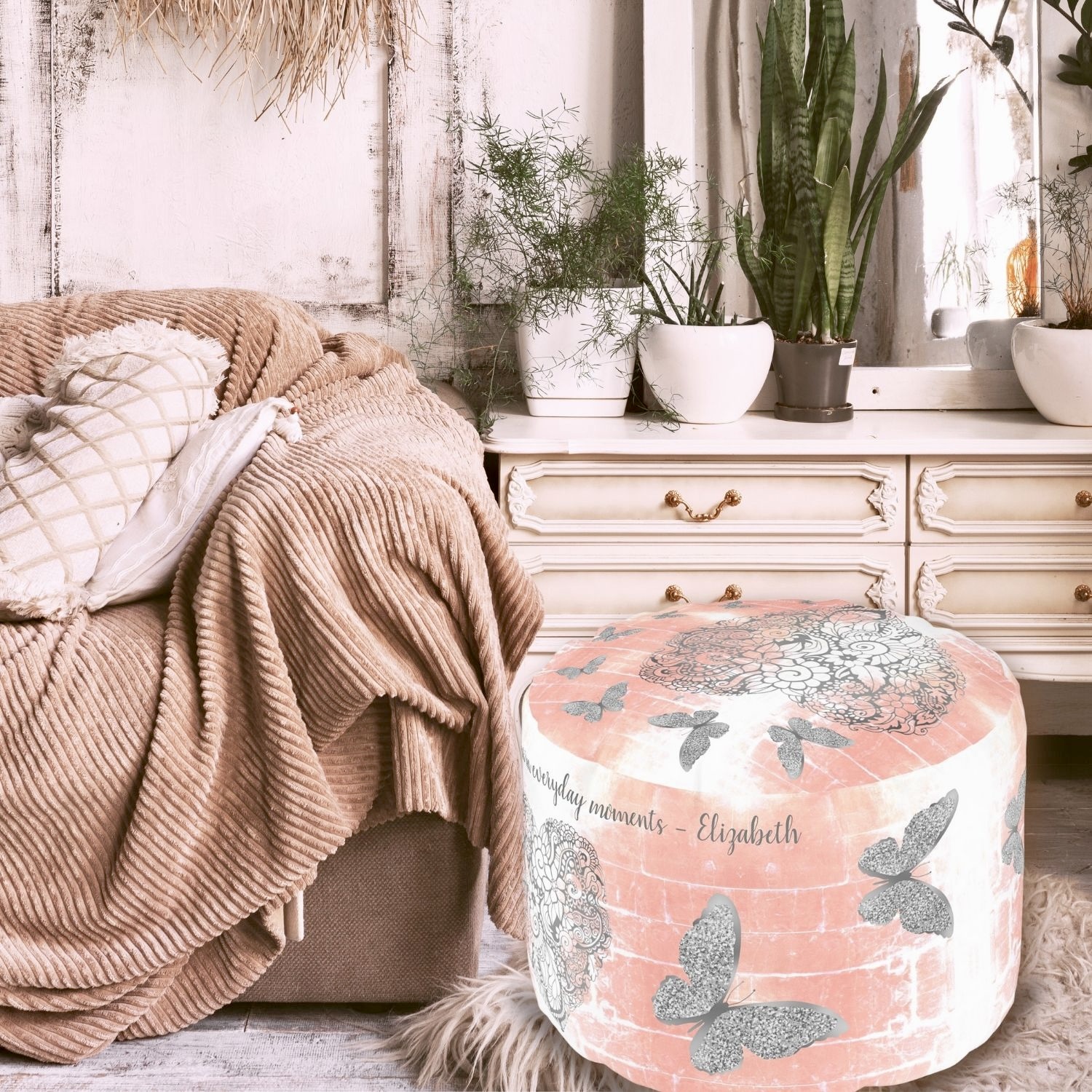 A rustic peach pouf with a gray heart centerpiece surrounded by silver butterflies, adding charm to a cozy bohemian bedroom.