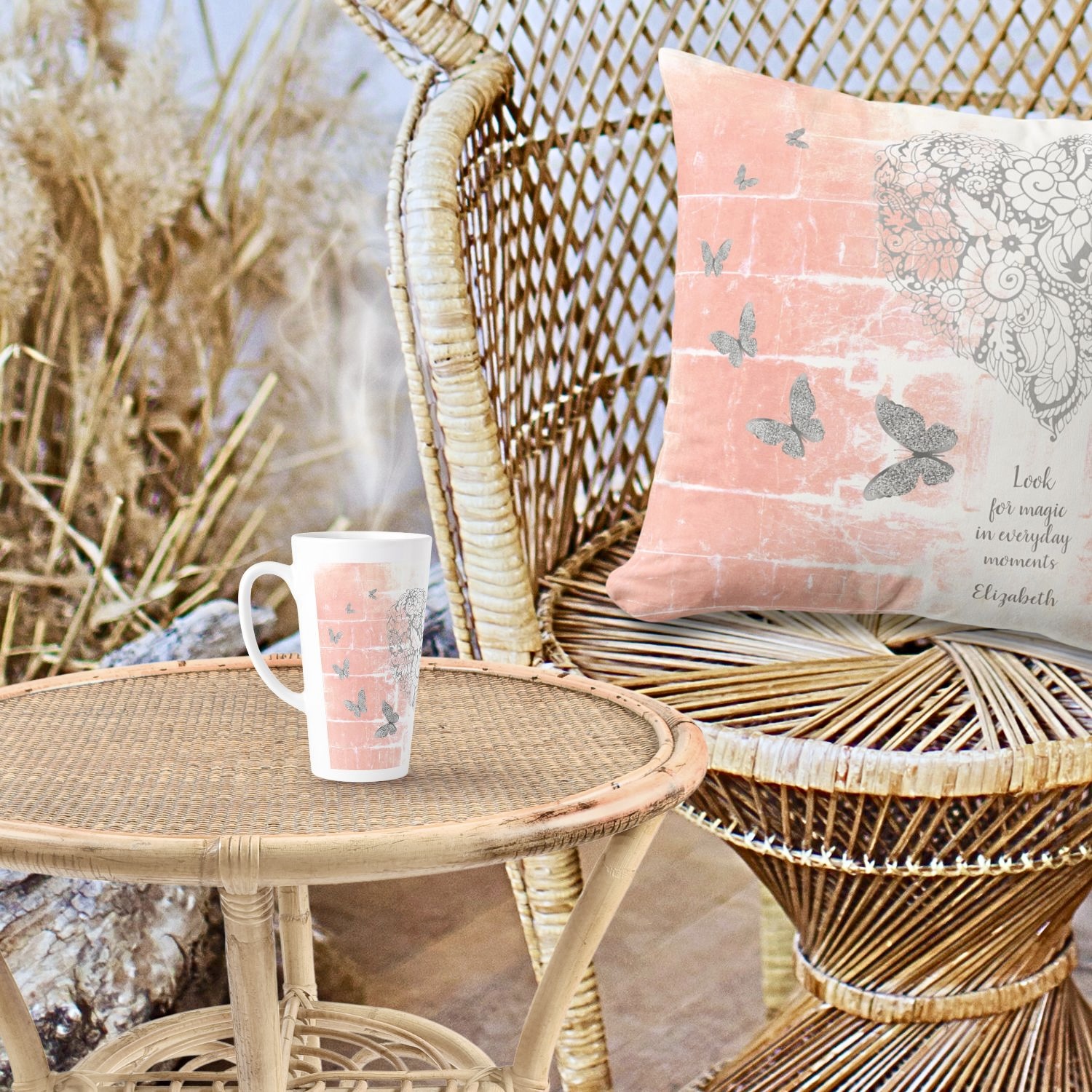 A latte mug and pillow displayed on wicker furniture, featuring serene peach tones and inspiring designs.